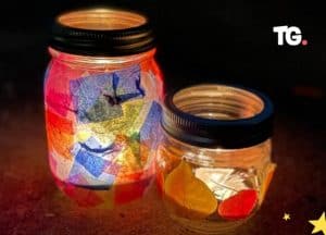 Colorful illuminated glass jars on dark background.