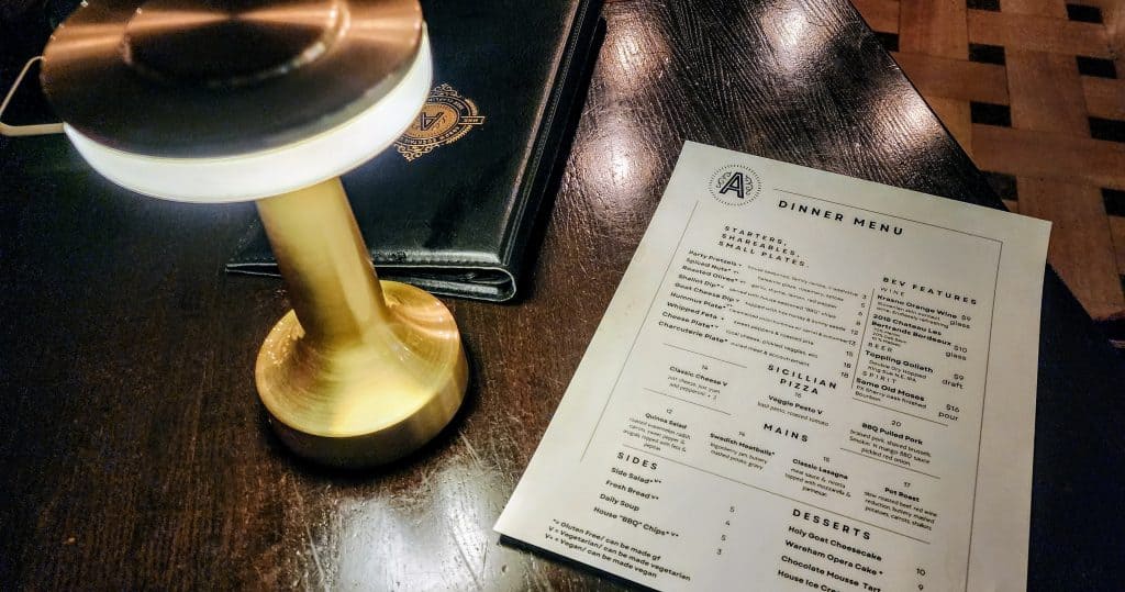 Glowing lamp over restaurant menu on table