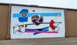 Colorful abstract knot mural on building wall.