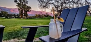 Lemonade on chair with scenic mountain view at sunset.