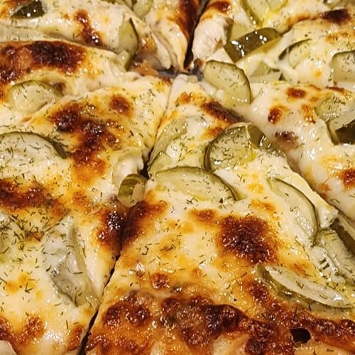 Cheesy pizza with pickles and dill seasoning.