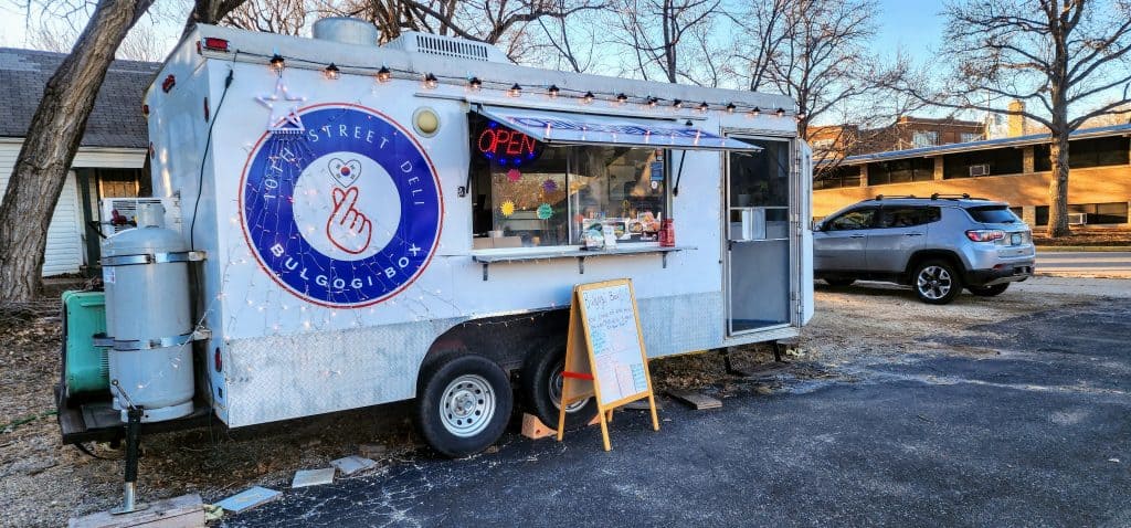 A food truck is parked in front of a house.