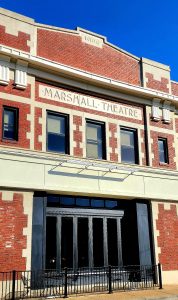 A brick building with a sign that says manshall tall theatre.