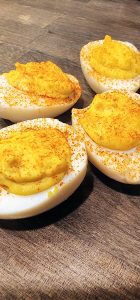 Deviled eggs with mustard on a wooden table.