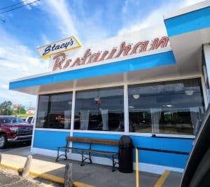A blue and white diner is parked in front of it.