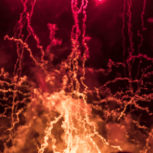 A close up of a firework on a dark night.