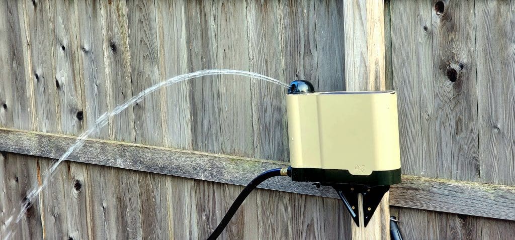 A water hose attached to a wooden fence.