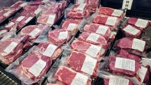Many packages of meat are on display in a grocery store.