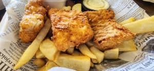 A basket of fish and chips on a table.