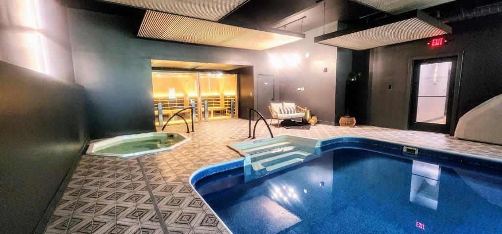 An indoor pool in a room with a door.