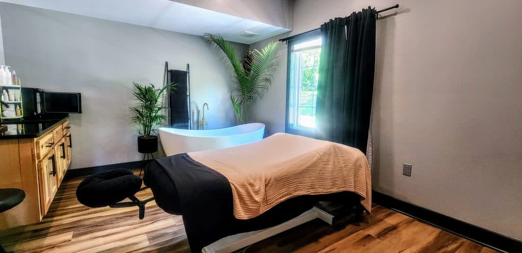 A room with a massage table and chairs.