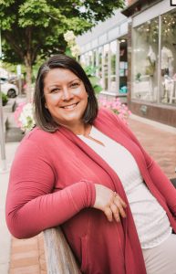 A woman in a red cardigan sitting on a bench.