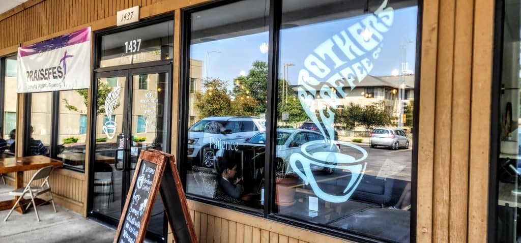 The outside of a coffee shop with a sign on it.