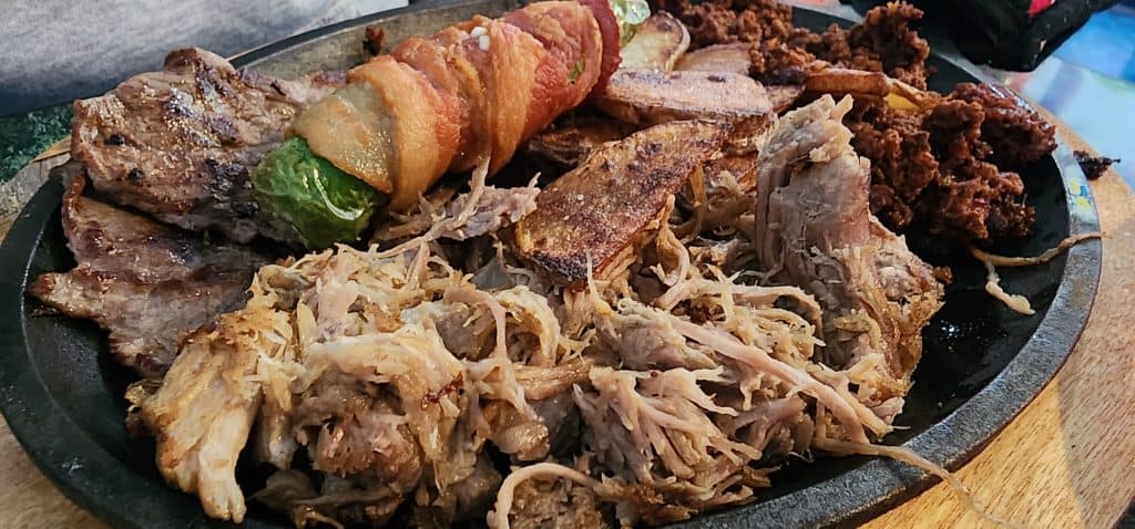A plate full of meat and vegetables on a table.