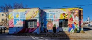 A community building with colorful murals on the side, creating a vibrant and welcoming atmosphere for families.