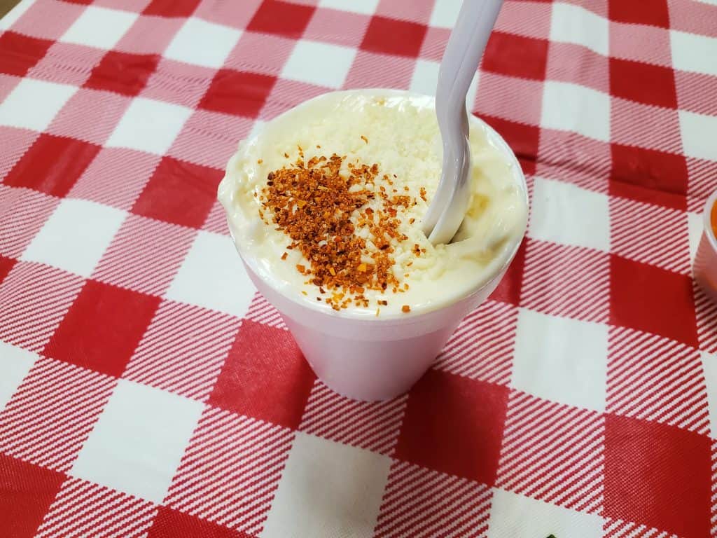 A cup of ice cream with a spoon on a red and white checkered table in Manhattan.
