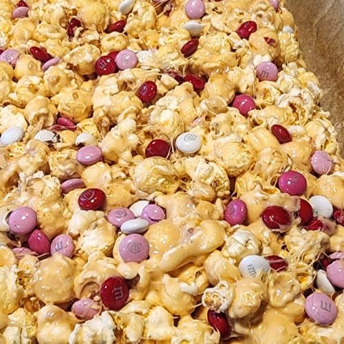 A box of caramel popcorn with candy.