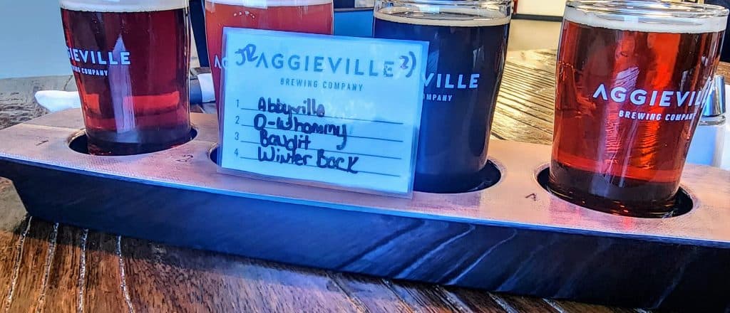 A sign on a coaster with a glass of beer.