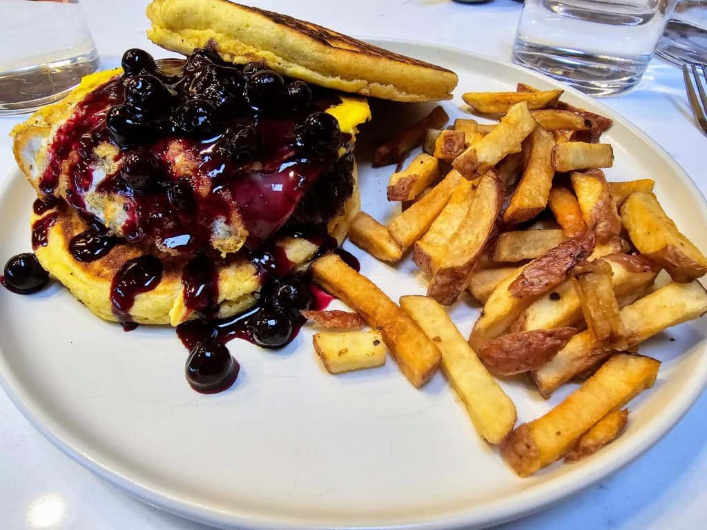 A plate of french fries and a burger with blueberry sauce in Parkside Station, KS.