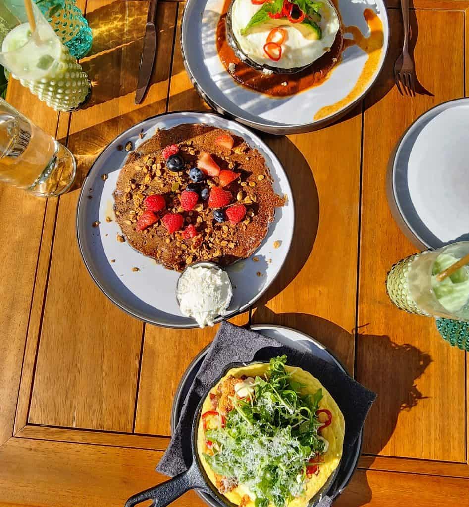 Three plates of food on a wooden table.