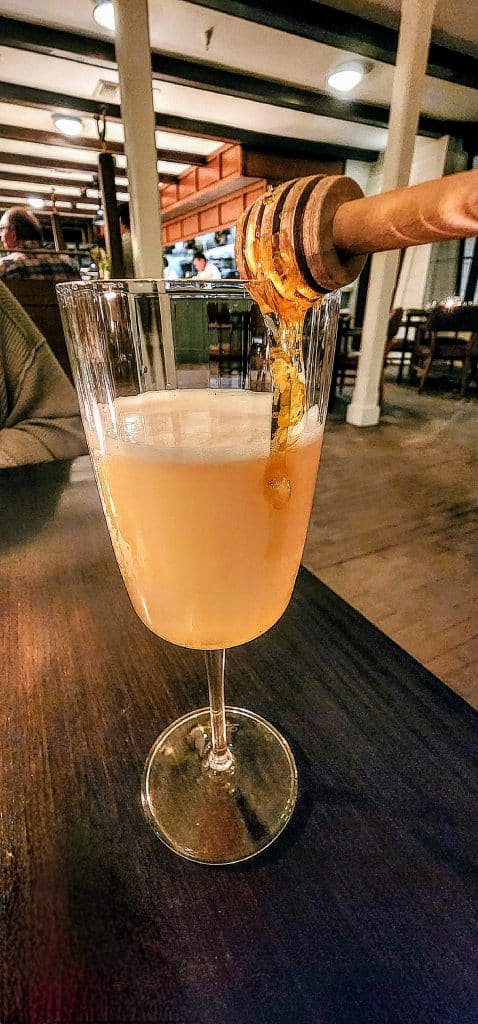 A cigar being poured into a glass of champagne.