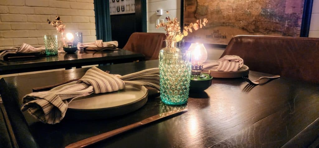 A table is set in a restaurant with candles.