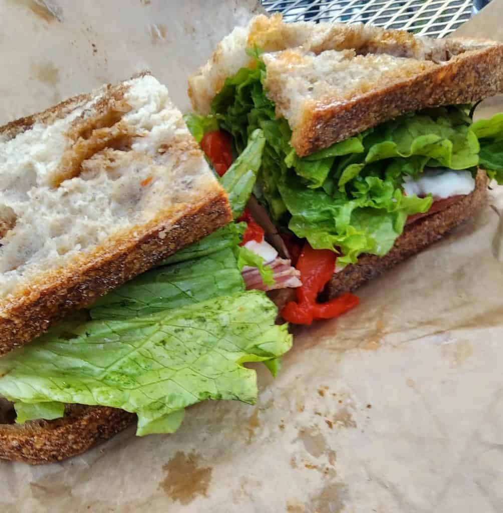 A Los Olivos Panino with lettuce and tomatoes.