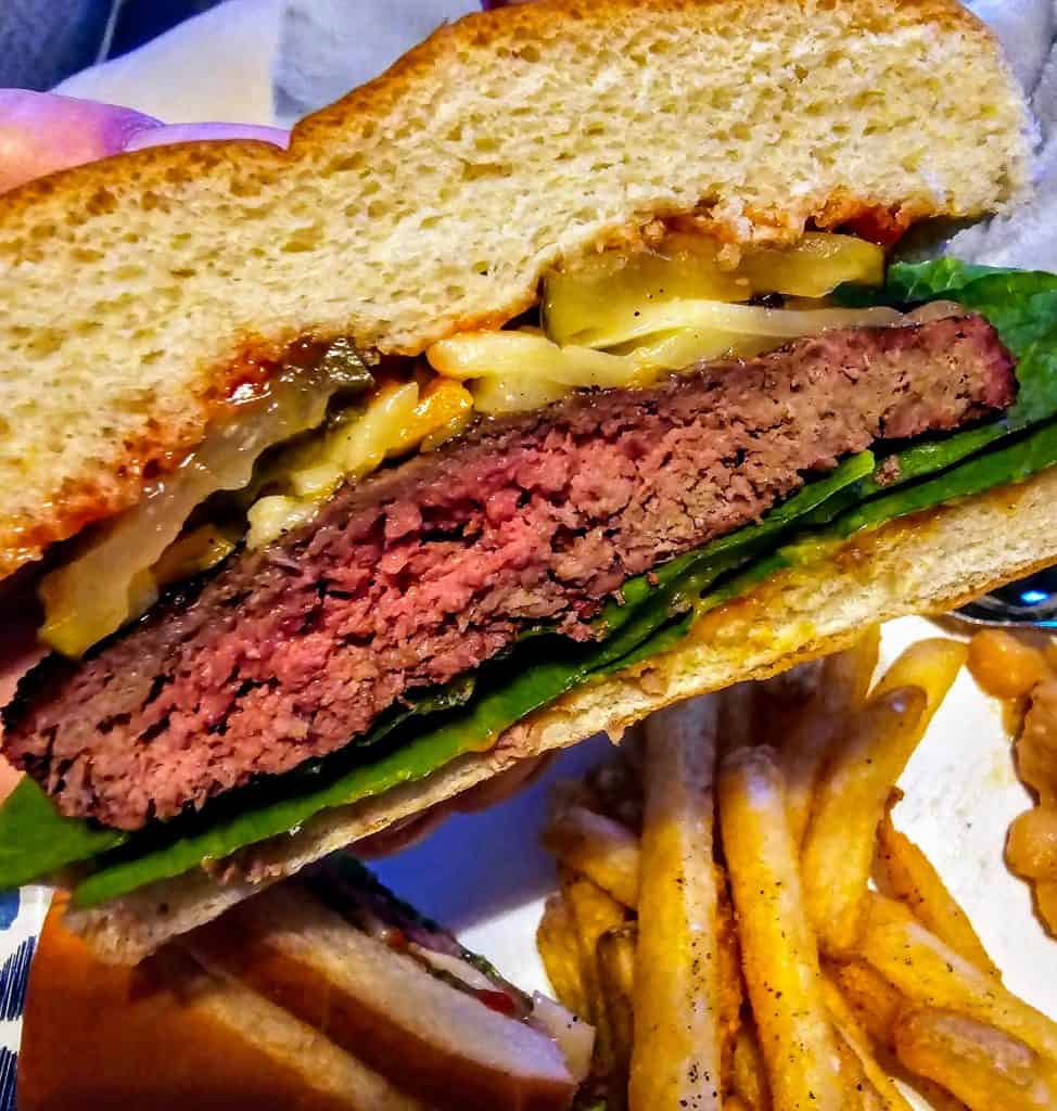 A Bison burger with fries and lettuce on a plate from Flint Hills Bison Company, Manhattan KS.