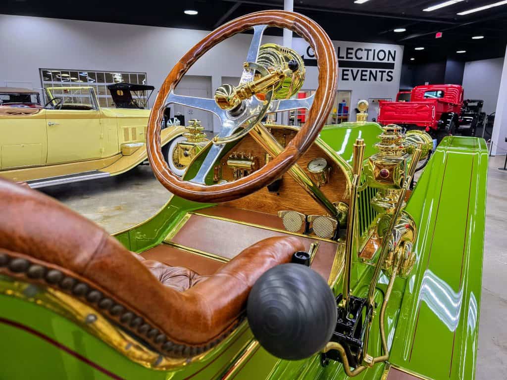Located in Manhattan, KS, this car museum showcases a unique green and brown vehicle equipped with a steering wheel.