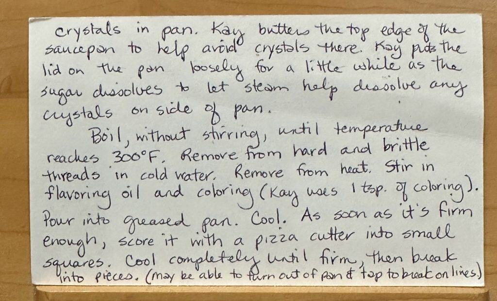 A handwritten recipe card for Aunt Kay's Old Time Candy, with steps to butter a pan, boil the mixture to 300°F, add flavor and color—like Cinnamon Candy—pour into a greased pan, and cut into small squares.